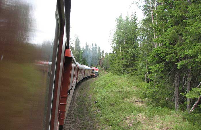 I uppförbackarna från Orsa upp mot högsta punkten. Bild framåt och bild bakåt. Tåget är långt och de båda dieslarna kämpar hårt och hörs vida omkring.  